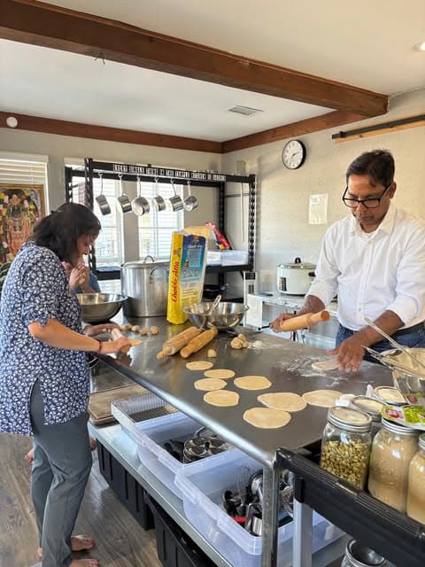 Volunteers rolling dough for thekua in a community kitchen